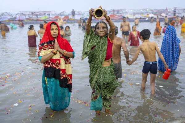 Hindu devotees pray before taking a dip at the confluence of the Ganges, the Yamuna and the mythical Saraswati rivers on the first day of the 45-day-long Maha Kumbh festival in Prayagraj, India, Monday, Jan. 13, 2025. (AP Photo/Ashwini Bhatia)